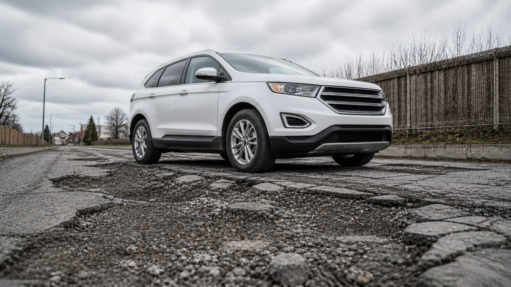 Everyday crossover on broken asphalt, underbody and oil pan close to potholes