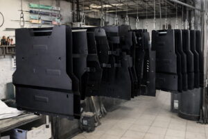 Finished steel skid plates hanging after powder coating